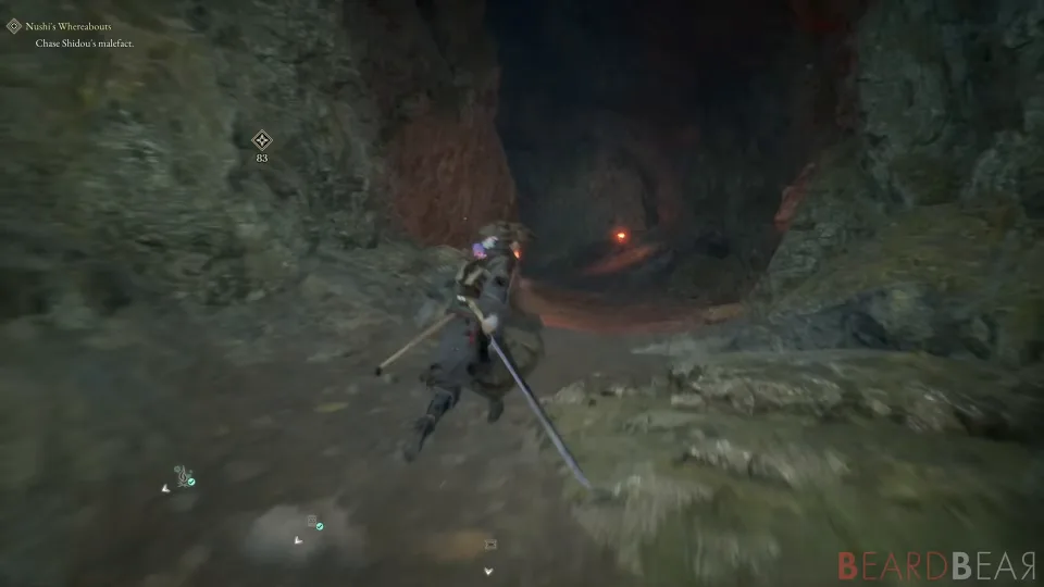 The player character with sword drawn at the mouth of a cave lit orange from within.